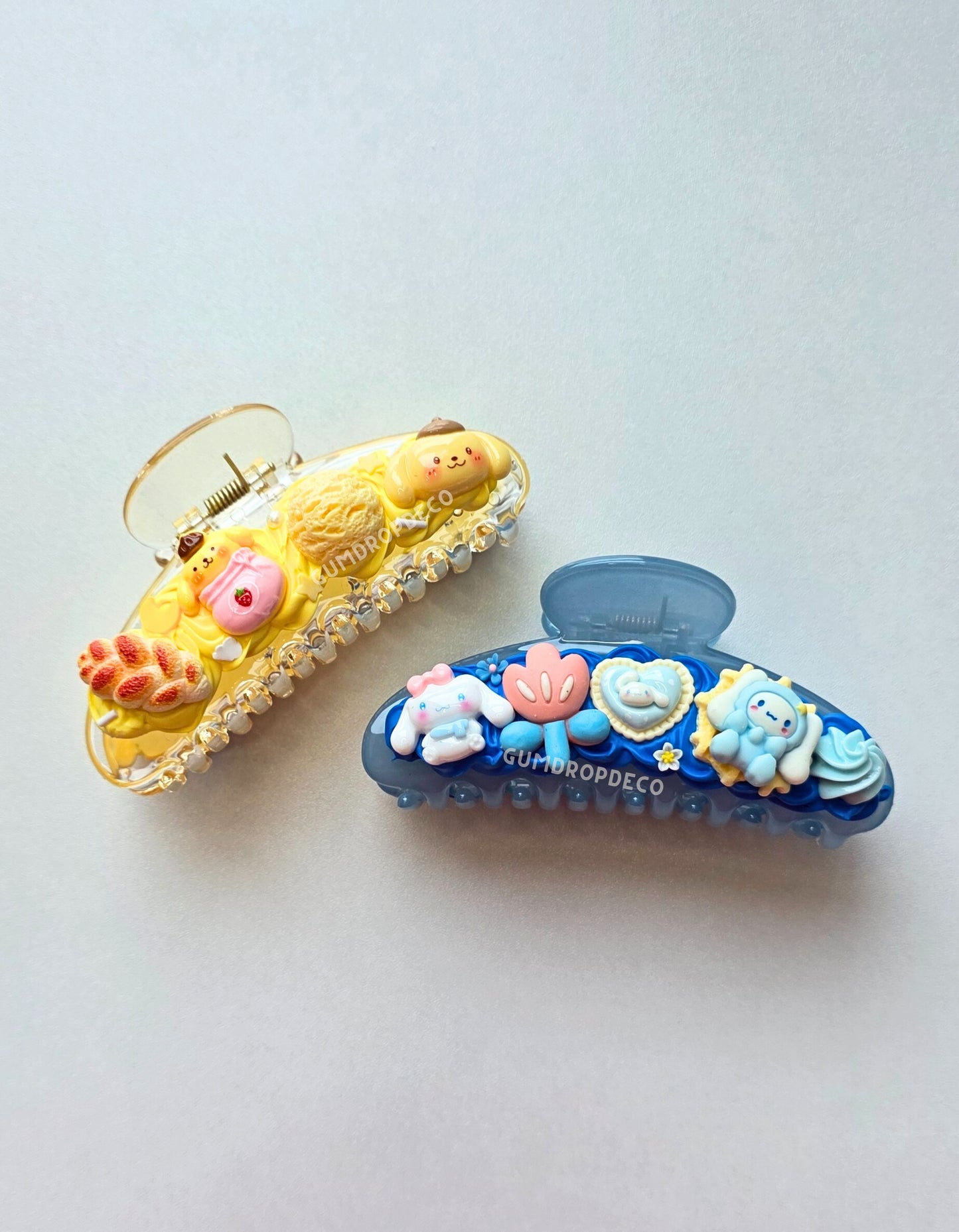 Close-up of decorative Decoden claw hair clip featuring colorful charms and strong grip. Sanrio Pompompurin and Cinnamoroll